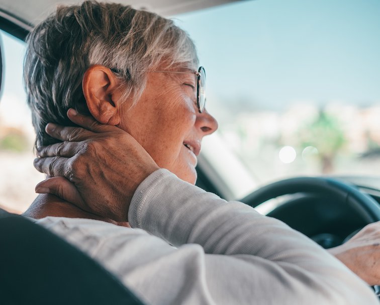 Driver holding her neck in pain after a car accident